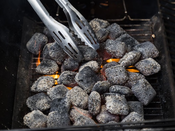 Light coals in a chimney starter and transfer to bottom grate when white.