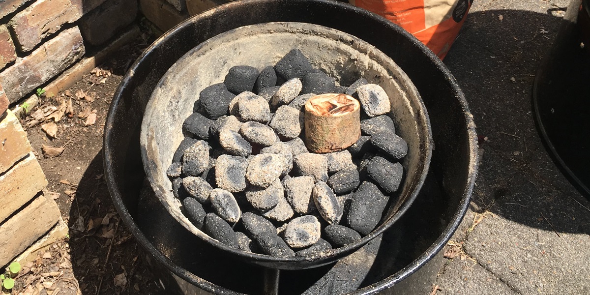 Heat up more briquettes in a chimney starter. When ready add to cold briquettes. Add your choice of wood chunk.