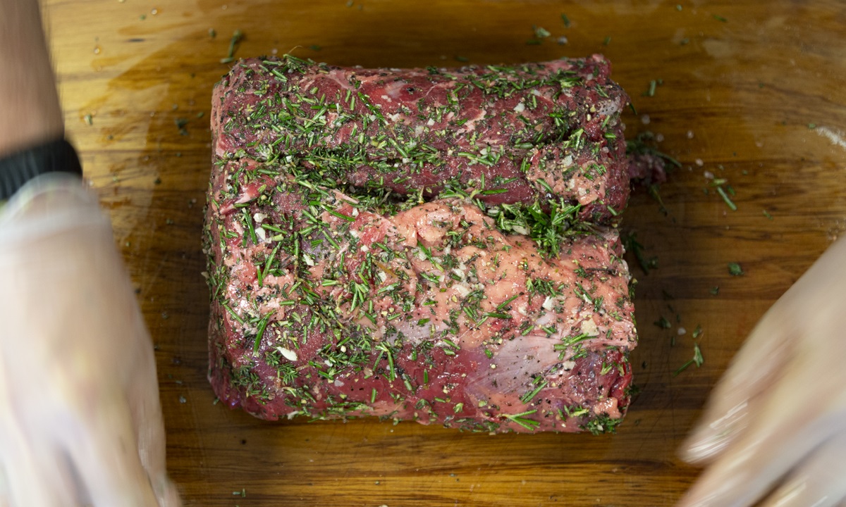 Rub with olive oil, this will help the herbs stick to the meat.