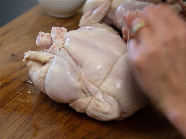 5. Wrap the twine back over the wings and flip the chicken over. Pull tight and tie off the twine.